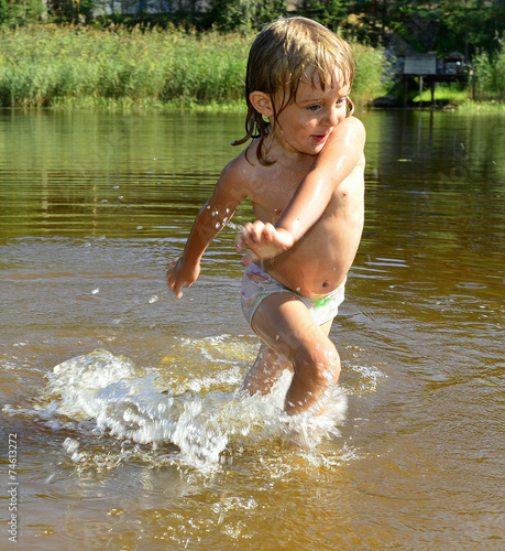 Fototapeta Naklejka Na Ścianę i Meble -  Little girl in water on sunny day