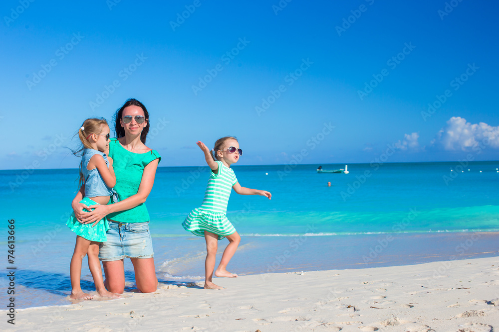 Little cute girls and young mother during tropical beach