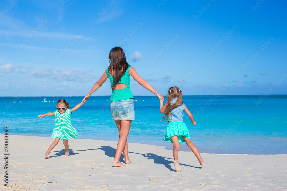 Little girls and happy mother during beach vacation