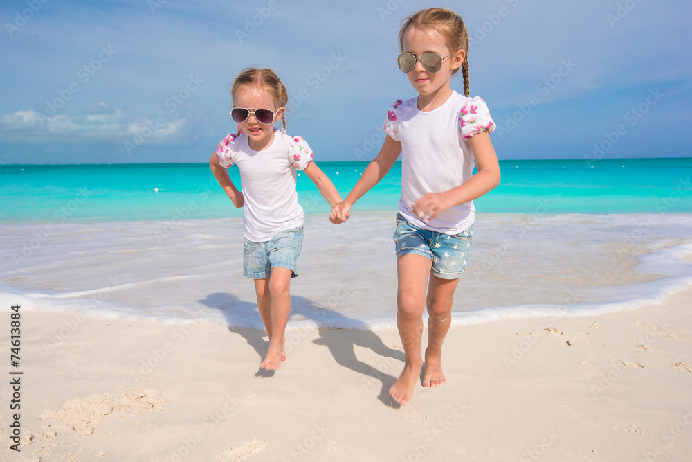 Little cute girls enjoy their summer vacation on the beach