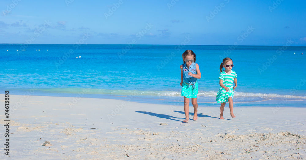 Adorable little girls enjoying summer beach vacation