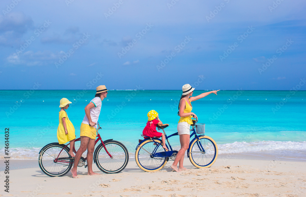 Young family riding bicycles on tropical beach Young family riding bicycles on tropical beach