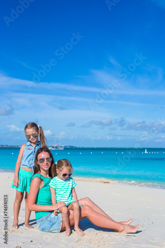 Little girls and happy mother during tropical beach vacation