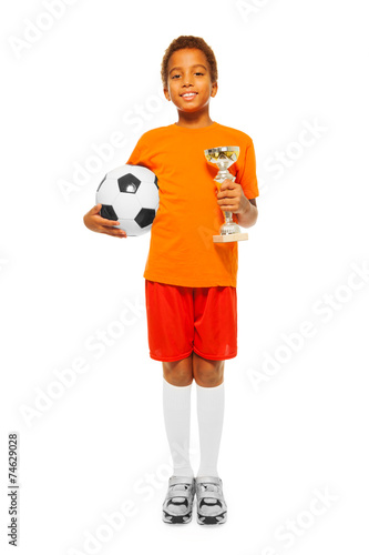 Fototapeta Naklejka Na Ścianę i Meble -  Little African boy holding soccer ball and prize