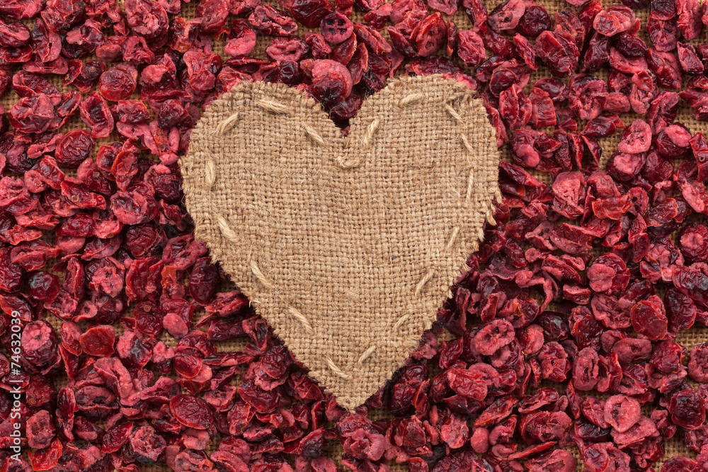 Heart of  burlap, lies on a background of dried cranberry