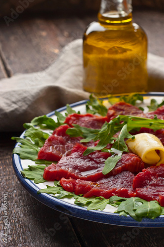 Carpaccio on the white plate on the wooden table