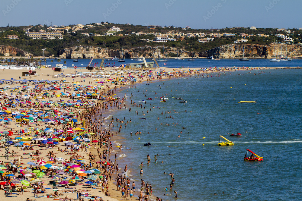 Broad view of a crowded beach on Portimao, Portugal.