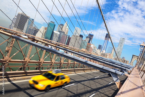 New York taxi crossing Brooklyn Bridge and Manhattan skyline