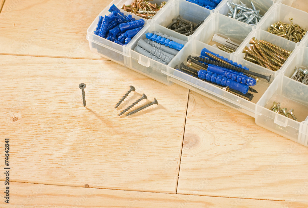 screws and toolbox on a wood background