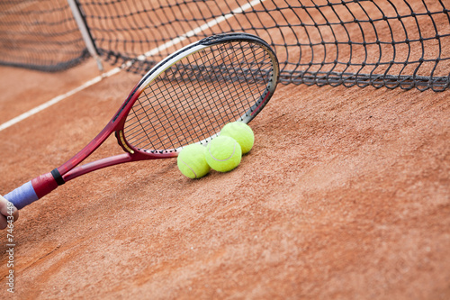 Close up of tennis racquet and balls on the clay tennis court  © pawel70