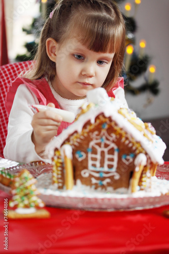 girl decorates gingerbread house