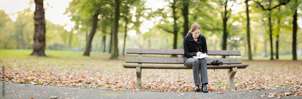 Woman with a Book and Notepad in a Park Woman with a Book and Notepad in a Park