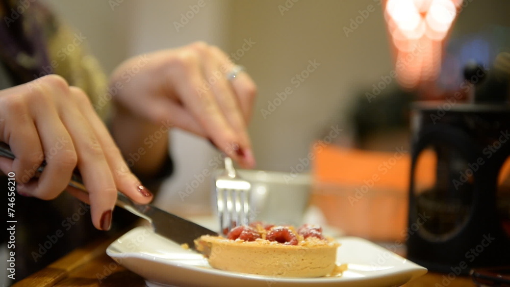 Close-up. Girl eats tartlet with raspberries in a bar, restauran Close-up. Girl eats tartlet with raspberries in a bar, restauran