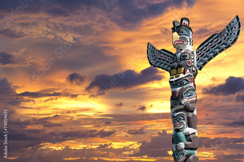 Canvas Print A totem wood pole in the gold cloudy background