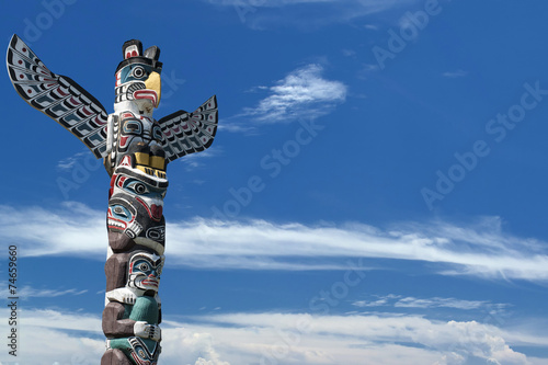 Totem wood pole in the blue cloudy background