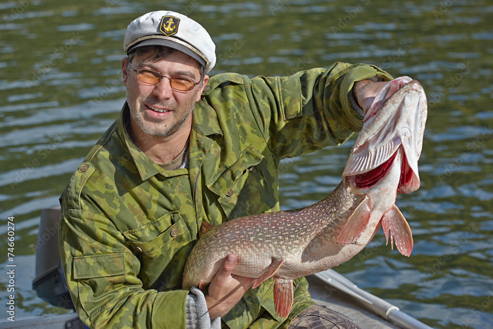 Fisherman holding a big pike