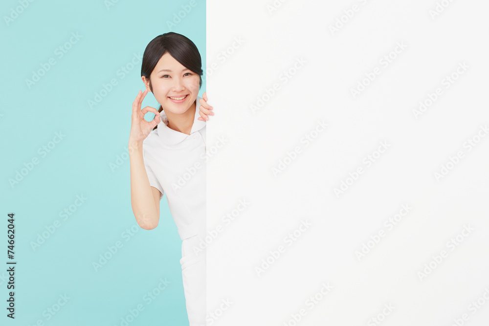 メッセージボードとOKサインするナース