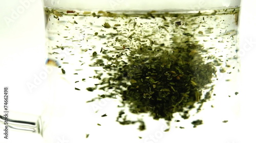 Loose leaf green tea dissolving in hot water in slow motion
