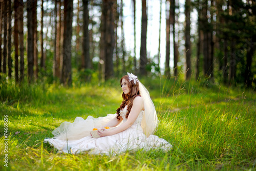 Young bride sitting on a grass