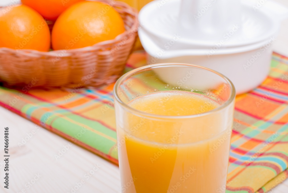 Orange fresh juice beside delicious ripe oranges on the table Orange fresh juice beside delicious ripe oranges on the table