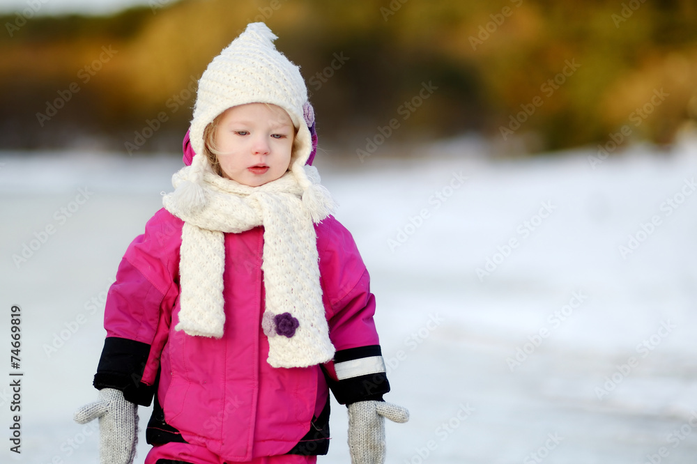 Adorable little girl at sunset on a winter day