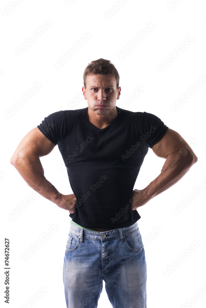 Angry muscular young man with fists on his hips Angry muscular young man with fists on his hips