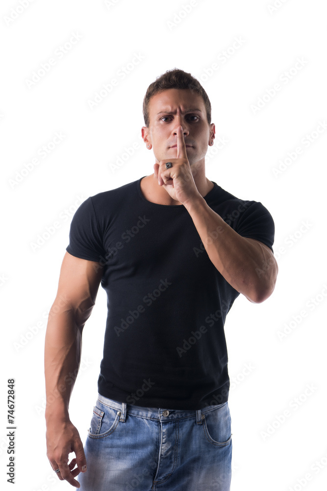 Young man doing shut up sign with finger on lips Young man doing shut up sign with finger on lips