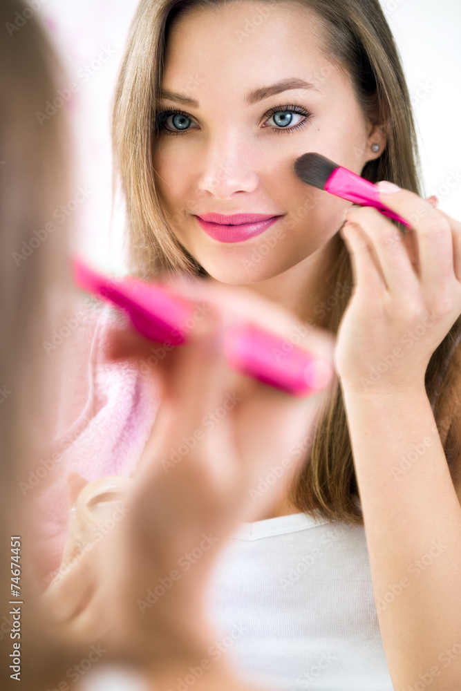 Reflection of young beautiful woman applying her make-up Reflection of young beautiful woman applying her make-up
