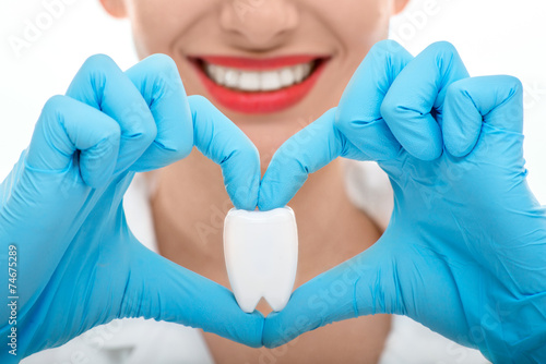 Slika na platnu Portrait of dentist with tooth on white background