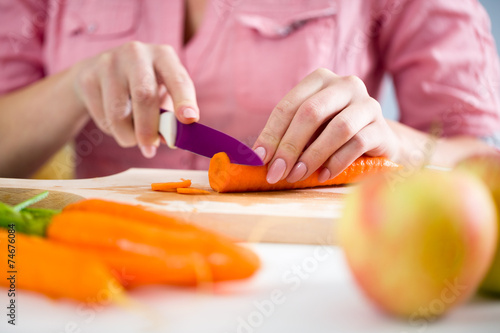 Hands of a young woman chopping vegetables