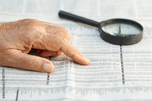 Senior woman reading stock listings