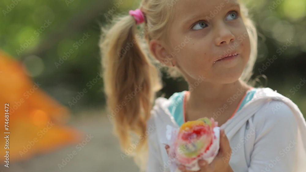 Amazing little girl with blue eyes eating cake with fruit on the Amazing little girl with blue eyes eating cake with fruit on the