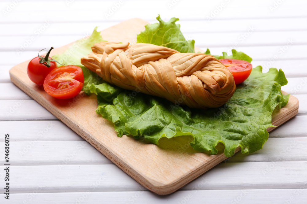 Smoked braided cheese on wooden table Smoked braided cheese on wooden table
