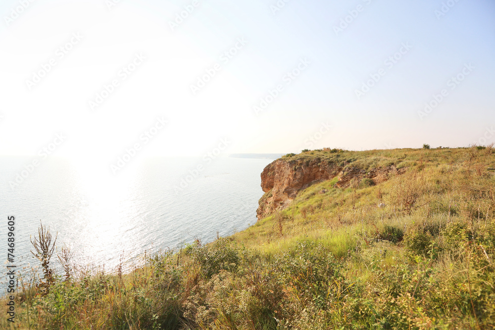 High green cliffs and precipices above the sea in a gentle sunse