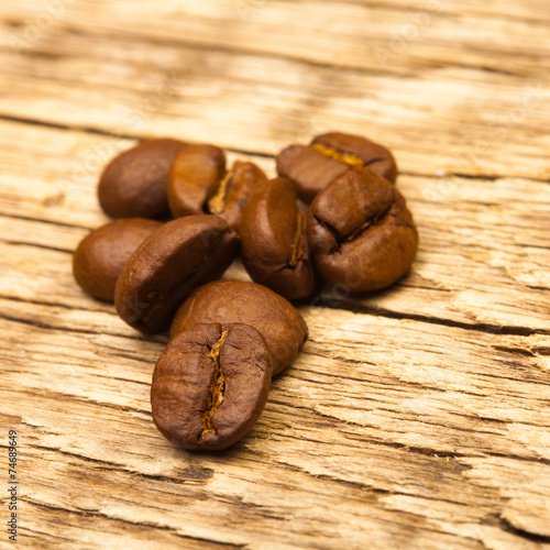 Neat roasted coffee beans on old wooden table
