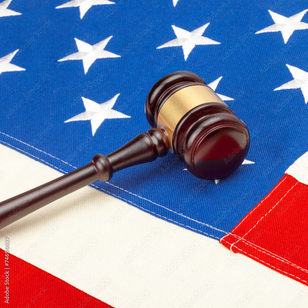 Wooden judge gavel over US flag - court judgment concept