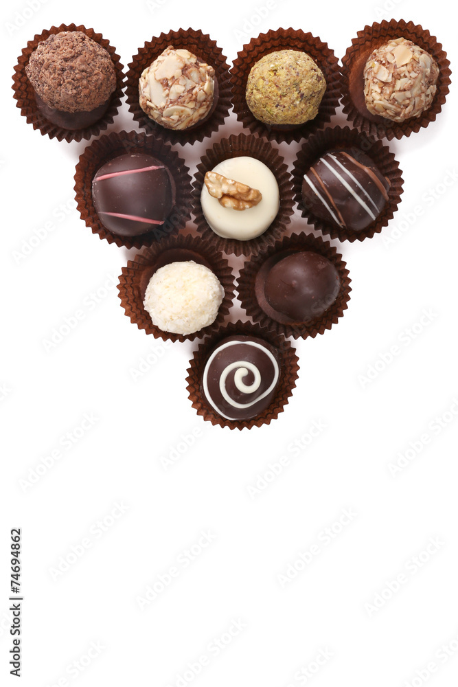 Group of round chocolates in paper bowls isolated Group of round chocolates in paper bowls isolated