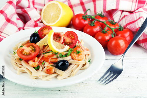 Tasty pasta with shrimps, black olives and tomato sauce