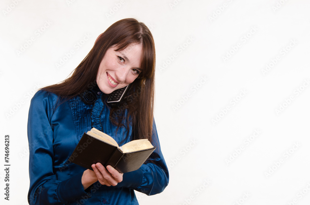 Business woman writing in a notebook on the phone Business woman writing in a notebook on the phone