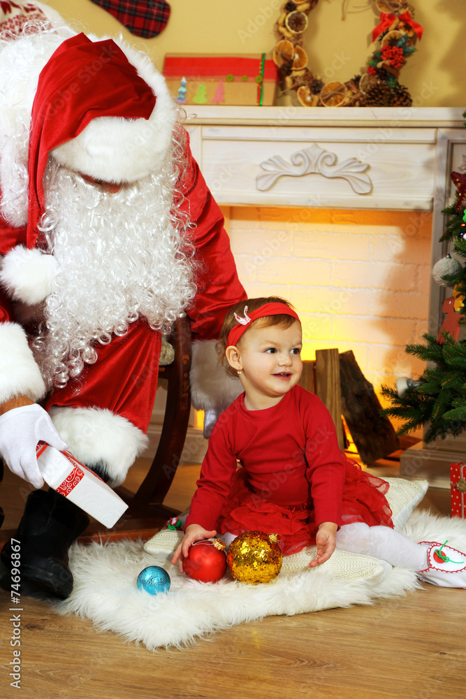 Santa Claus giving  present to  little cute girl near