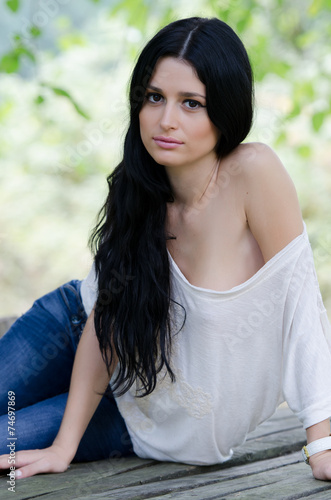 Woman in white shirt and jean lie over wooden surface