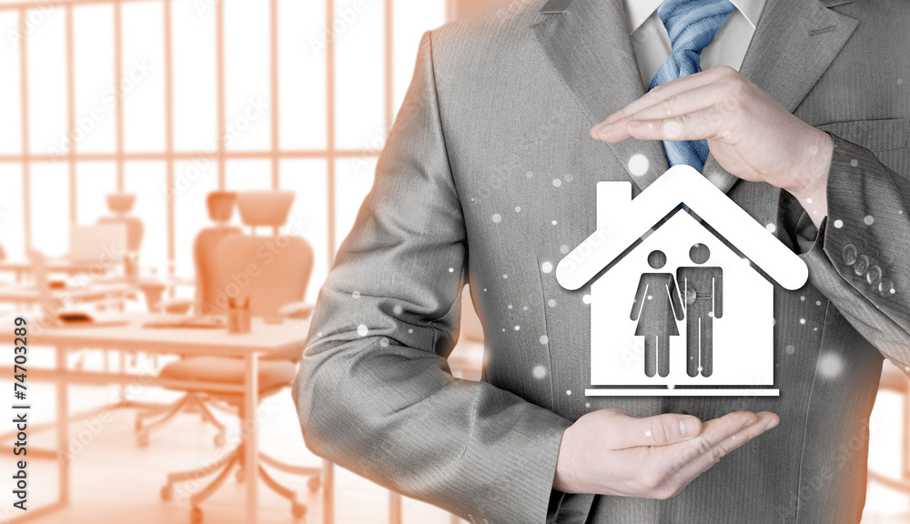 businessman protecting family in home with hands businessman protecting family in home with hands