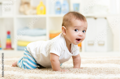 Fotografiet crawling baby boy indoors