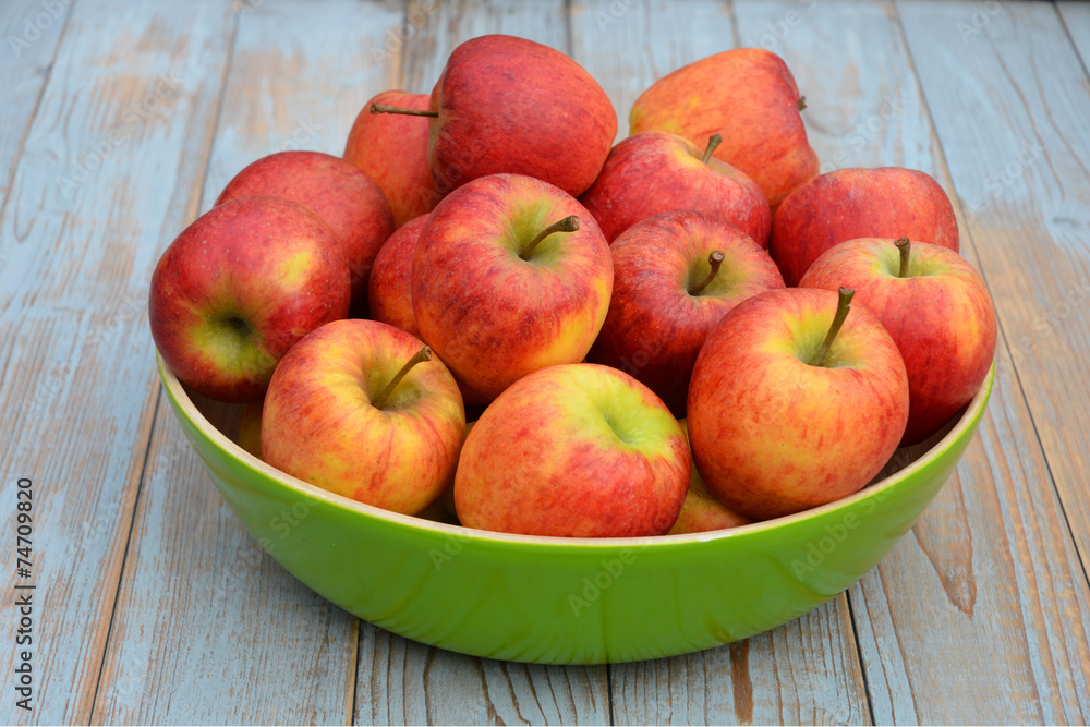 Verse appels in groene fruitschaal op oud hout Verse appels in groene fruitschaal op oud hout