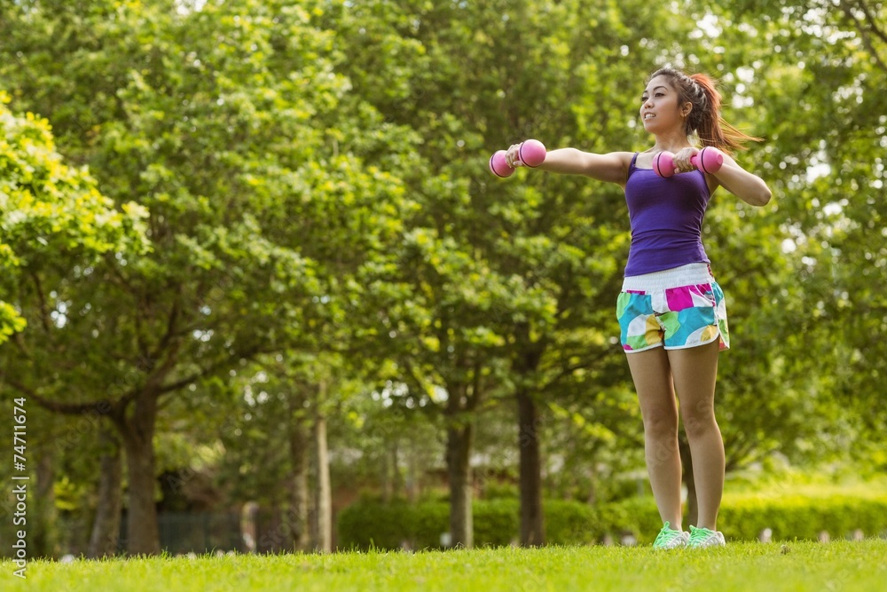 Healthy woman lifting dumbbells in park Healthy woman lifting dumbbells in park