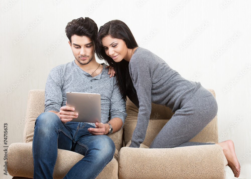 Young happy couple looking at tablet PC screen Young happy couple looking at tablet PC screen