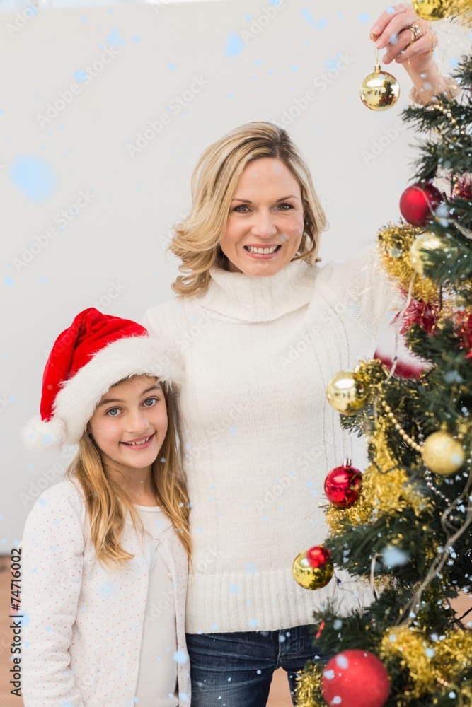 Festive mother and daughter decorating christmas tree Festive mother and daughter decorating christmas tree
