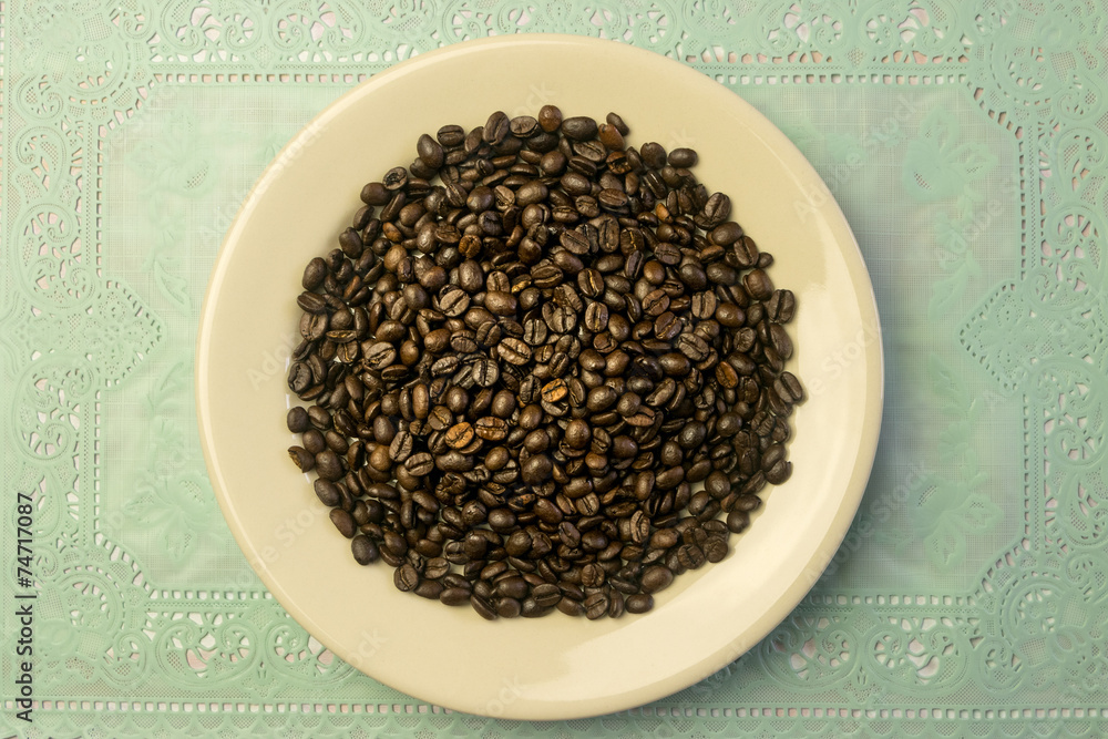 White round plate with a heap of coffee beans White round plate with a heap of coffee beans
