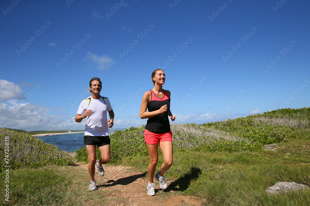 Couple running by the sea on track