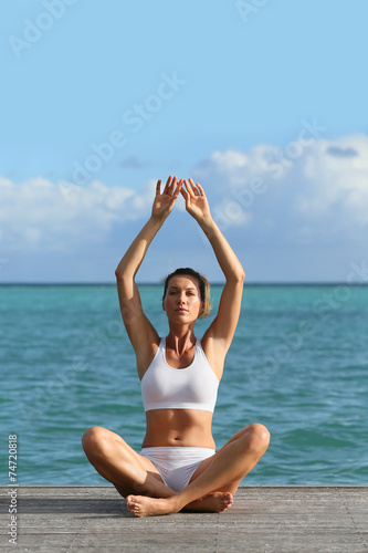 Woman doing yoga exercises by the sea